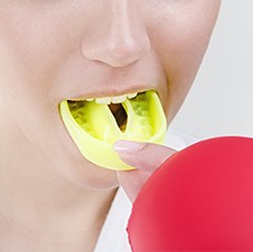 Closeup of teen placing mouthguard