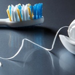 Toothbrush and dental floss on reflective cabinet