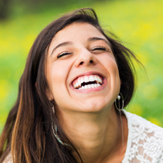Woman with flawless smile after porcelain veneer placement