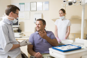 Smiling man in dental chair talking to dentist