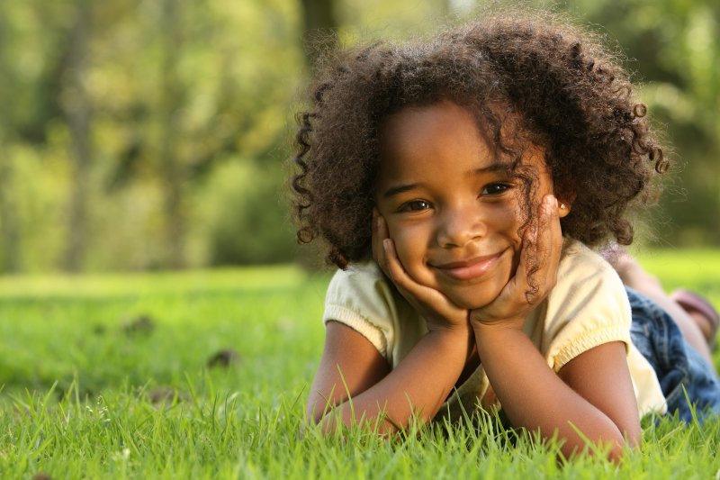 little girl smiling hands on face