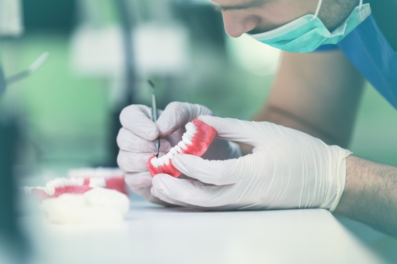 Dentist works to clean dentures
