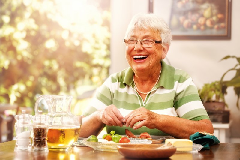 older woman enjoying summer foods with dentures